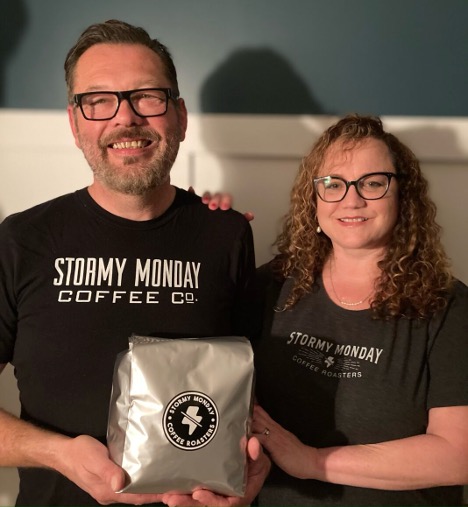 Joe and Barb DeSouza holding a bag of Stormy Monday coffee
